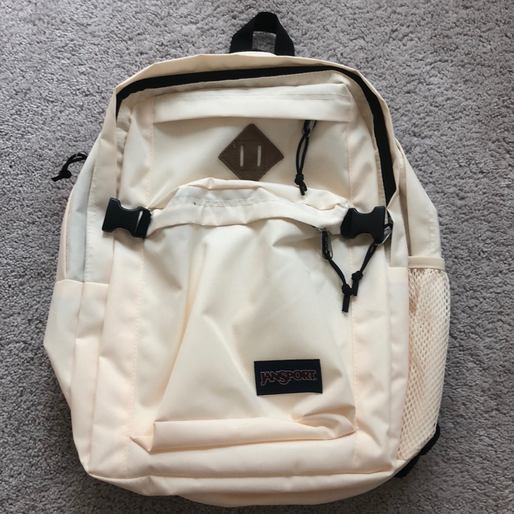 Jansport backpack. Cream/little yellow. With 4 places to put things in.